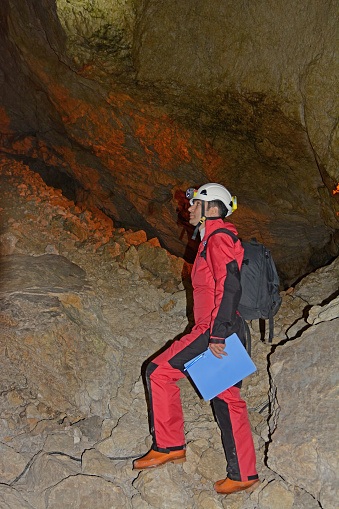 A man in a cave suit exploring a cave.