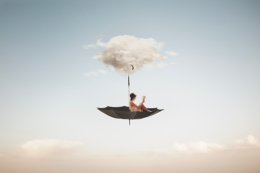surreal woman reading a book flies on an overturned umbrella