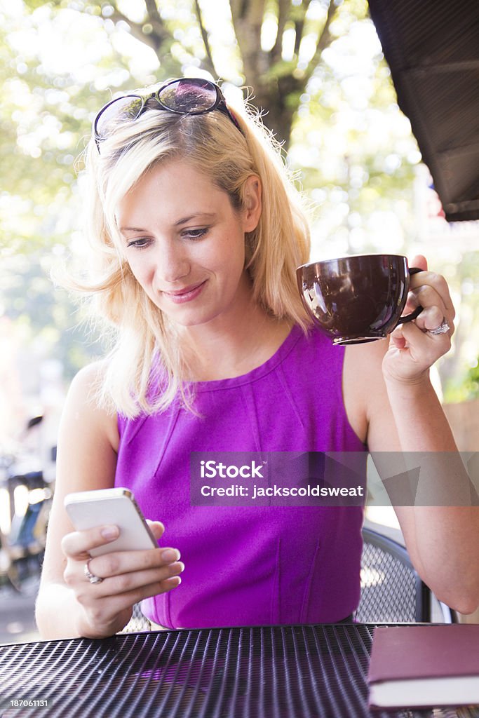 Mulher bonita usando seu telefone inteligente em um café ao ar livre - Royalty-free Magenta Foto de stock