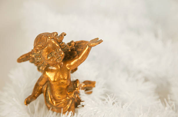 This colorful image depicts a figurine of a hanging angel holding a banner on which is indicated the word Gloria. Christmas crib.