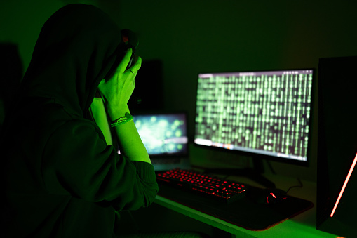 Young Female Hacker using a Computer to Attack another system