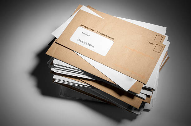 istock Large stack of brown and white mail on a gray background 187062327