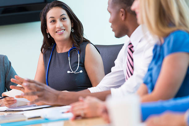 Hospital doctors, nurses, and administration talking during staff meeting Hospital doctors, nurses, and administration talking during staff meeting healthcare and medicine business hospital variation stock pictures, royalty-free photos & images