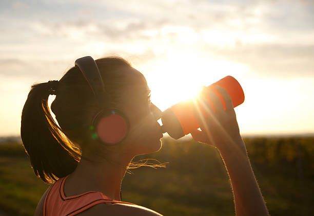 istock Woman drinking water at sunset 187063818