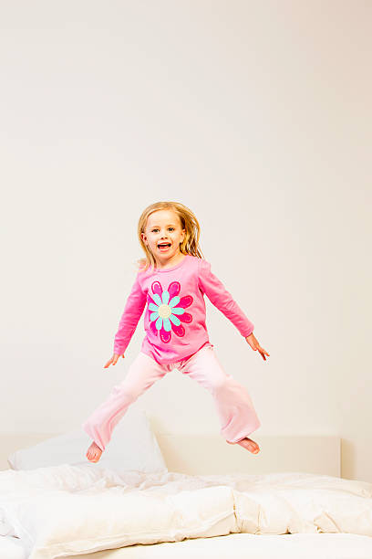istock Girl Jumping On A Bed 187063904