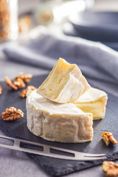 istock Brie type cheese with white mold. French camembert cheese on cutting board. 1870641836