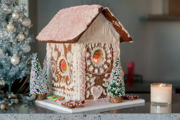 Gingerbread house with white and pink icing. Homemade for Christmas holiday. Landscape horizontal side view.