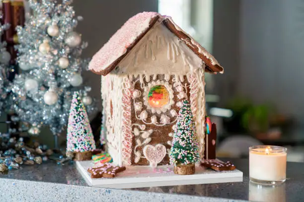 Gingerbread house with white and pink icing. Homemade for Christmas holiday. Landscape horizontal front view.