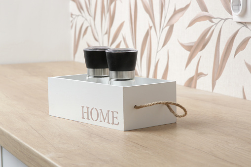 Salt and pepper containers in the wooden box on the kitchen counter