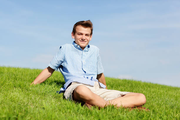 istock Happy Young Man Sitting Outdoor on Meadow 187067079