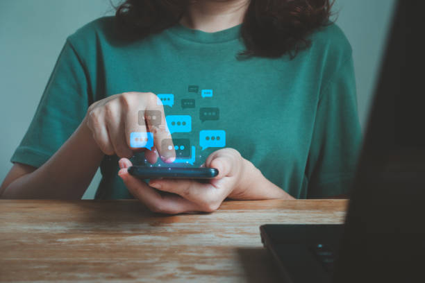istock Young woman using mobile smartphone and computer laptop on wood desk. Online live chat chatting on application communication digital media websites and social networks. 1870683591
