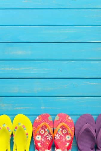 Colored thongs on a blue decking background with copy space