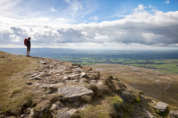 Hiker at the top of Ingleborough A male hiker admires the view from the top of Ingleborough, one of the Three Peaks in the Yorkshire Dales National Park, North Yorkshire, England. ingleborough stock pictures, royalty-free photos & images