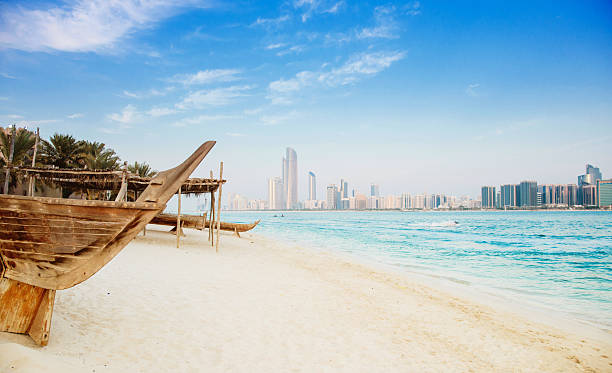 Beautiful Abu Dhabi Beach Traditional dhows at the beautiful white Marina beach of Abu Dhabi with the city´s growing skyline in distance. dhow photos stock pictures, royalty-free photos & images