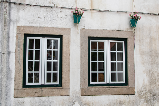 Two windows on the wall of an old house in Montenegro.
