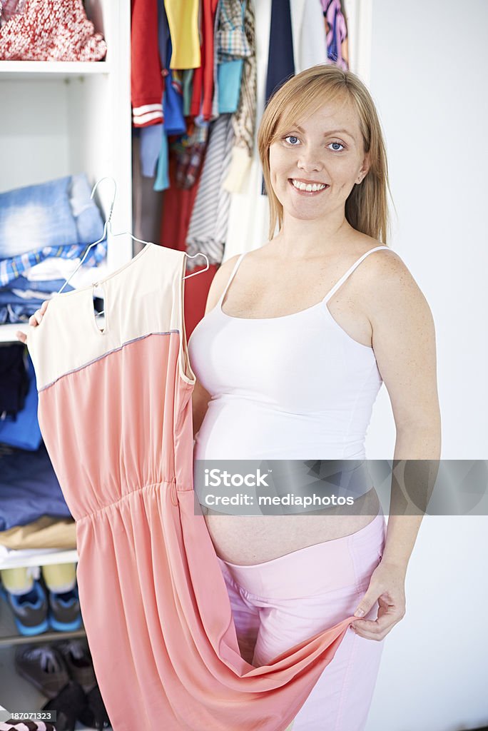 I will fit to this dress soon! Adorable pregnant woman holding smart dress 20-29 Years Stock Photo