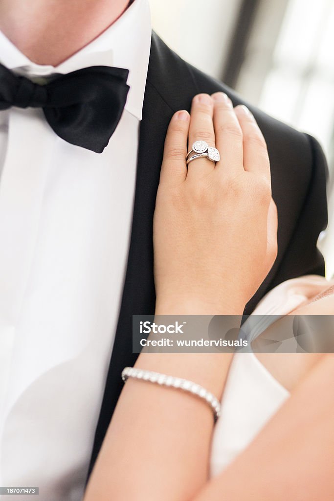 Dettaglio di anello nuziale con la sposa e lo sposo - Foto stock royalty-free di Abbigliamento formale