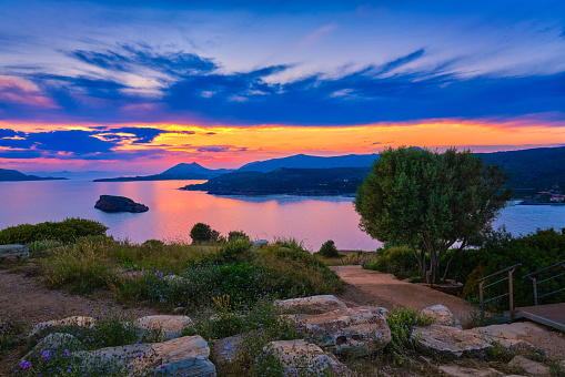 Sunset at ancient Temple of Poseidon, Sounio, Greece. Tranquil coastal landscape with clear blue waters.