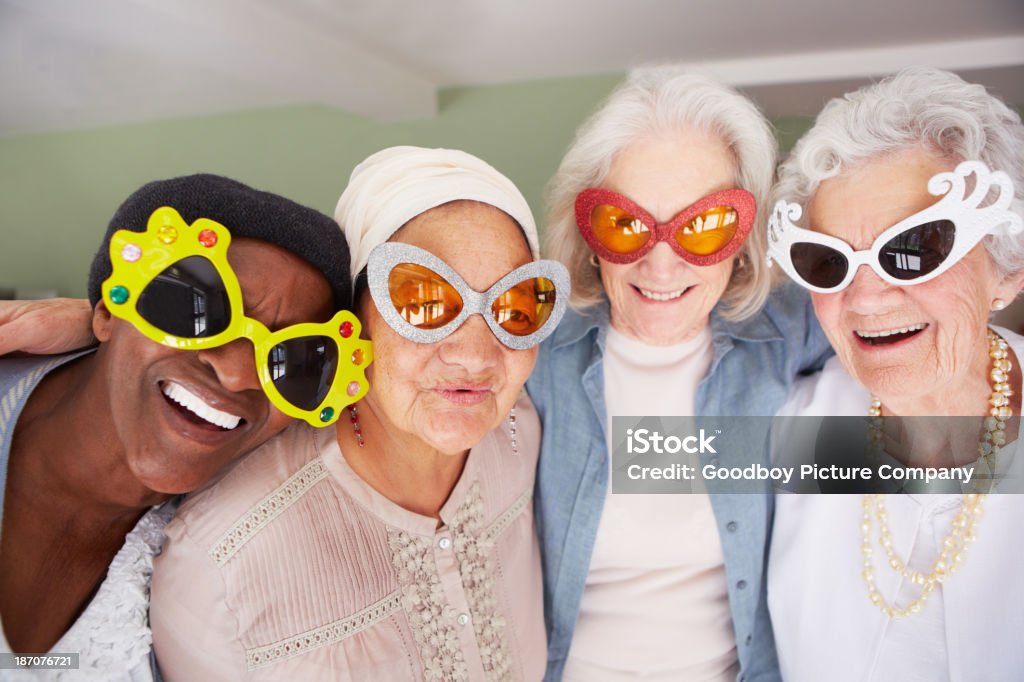 Your grandma can never be this cool! A group of elderly woman wearing funky sunglasses while standing in a nursing home Senior Adult Stock Photo