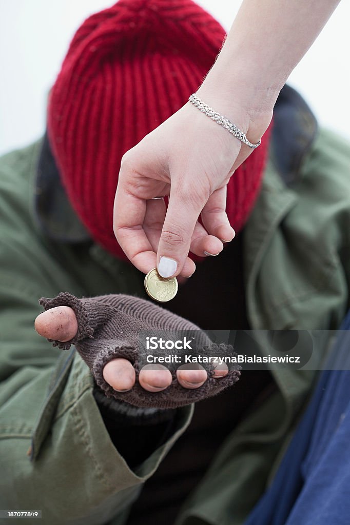 Benefit for homeless man Women giving a coin for homeless poor man Homelessness Stock Photo