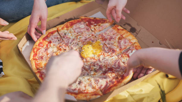 istock Young students' hands reach for the pizza. 1870782189