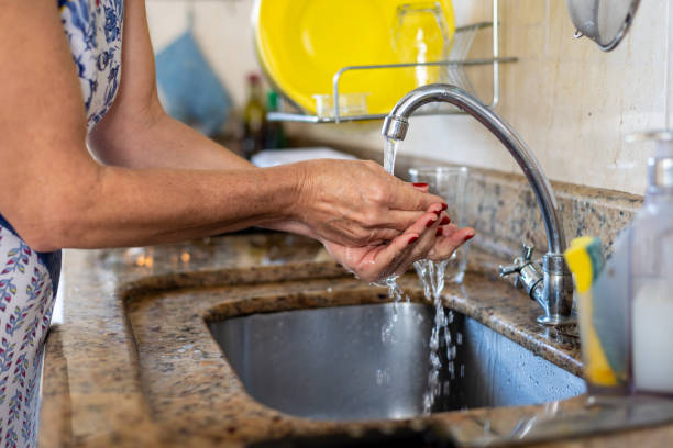 istock A woman, in the kitchen, washing her hands thoroughly before cooking. 1870784808