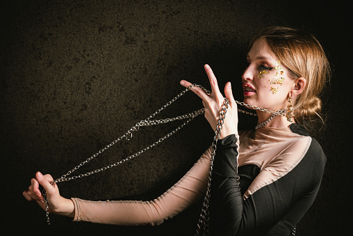 Portrait of young woman with chain necklace