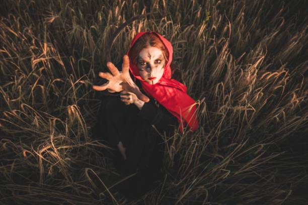 istock Fantasy witch in agricultural field with sickle 1870789823