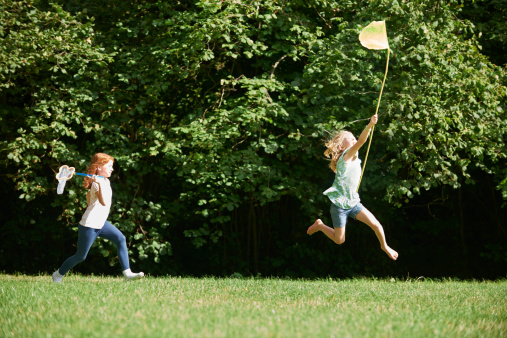 Children running off energy in summer field