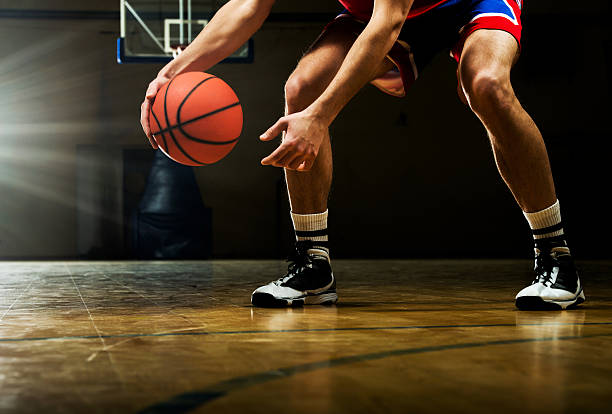 Unrecognizable basketball player dribbling.