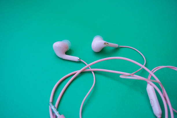 istock Pink wired earphones isolated over green 1870809464