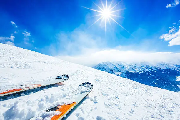 Skis on top of slope in ski resort against sun. Click for more similar images: