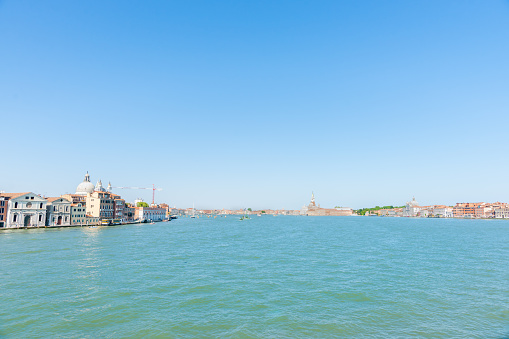 Venice Italy - May 10 2011; Characteristic and famous waterfront in wide vista of Grand Canal under clear blue sky