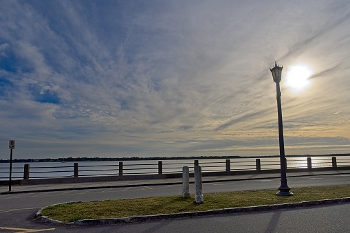 Sun sets over battery wall and harbor at south end of the historic city of Charleston South Carolina.