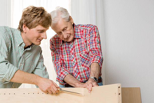istock Collaboration: Grandfather and grandson assembling furniture 187083873