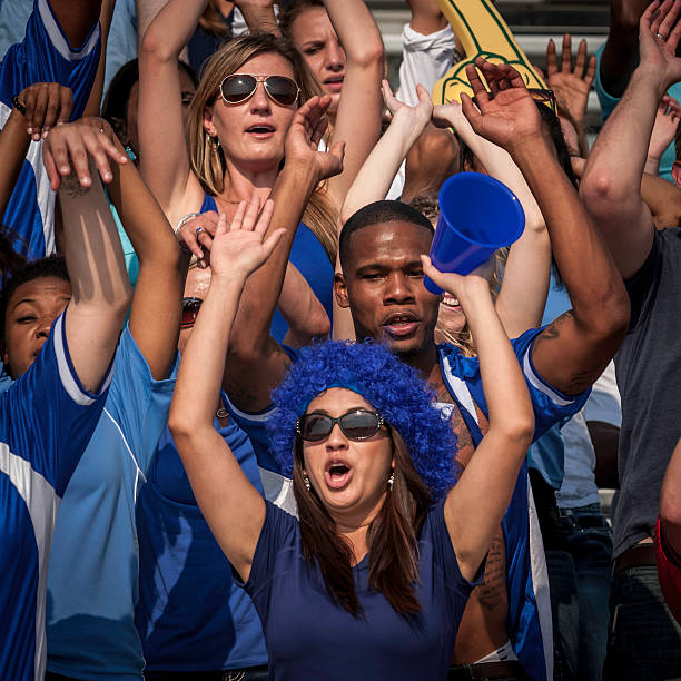 istock Fans in blue with raised arms cheering for their team 187084576