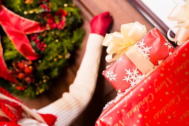 weihnachten: frau klopft an tür mit geschenken zu bieten. - neighbors at the front door stock-fotos und bilder