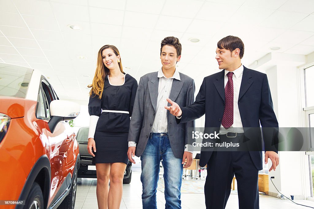 Vendeur de voitures présentant aux clients un SUV - Photo de Acheter libre de droits