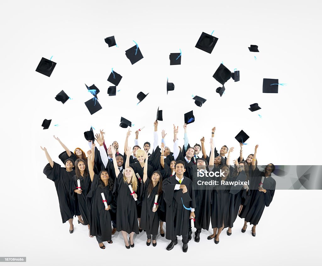 Cappelli laurea gettati in aria - Foto stock royalty-free di Scontornabile