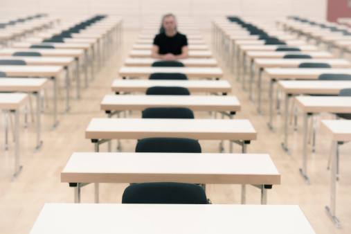 Single person in an examination hall. Selective focus on the first rowlearning, loneliness or the looser.