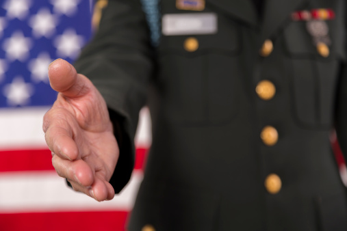 Senior army officer reaches out his hand as a symbol of service to his country.