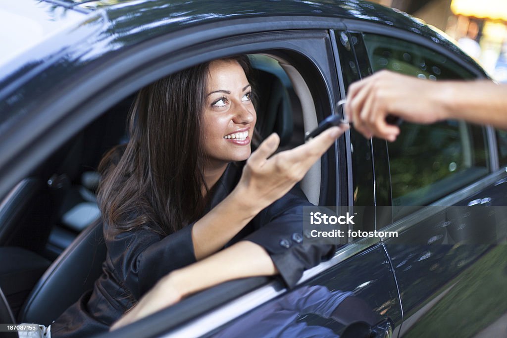 Woman buying new car Young woman buying new car, reaching for the car keys. Car Key Stock Photo