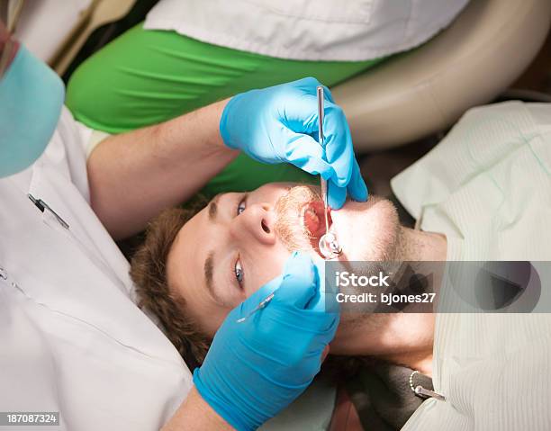 Junger Mann Beim Zahnarzts Hat Einen Zahn Gefüllt Stockfoto und mehr Bilder von Allgemeinarztpraxis - Allgemeinarztpraxis, Ausdauer, Ausrüstung und Geräte