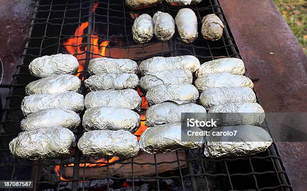 Foto de Foil Envolto Batatas Assadas De Culinária No Fogo Aberto Chamas e mais fotos de stock de Batatas Prontas