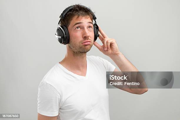 Young Man With Headphones Listens To Something Boring Stock Photo - Download Image Now