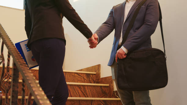 istock Businesspeople standing on stairs discussing in office building 1870877631