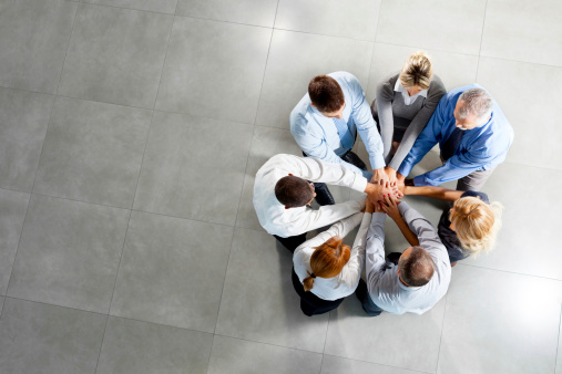 Photo of business people with hands on top.High angle view