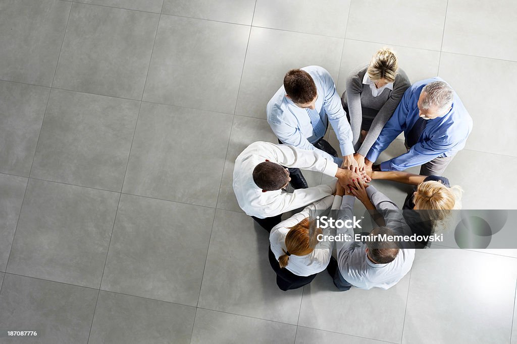 Photo of business people with hands on top Photo of business people with hands on top.High angle view Circle Stock Photo