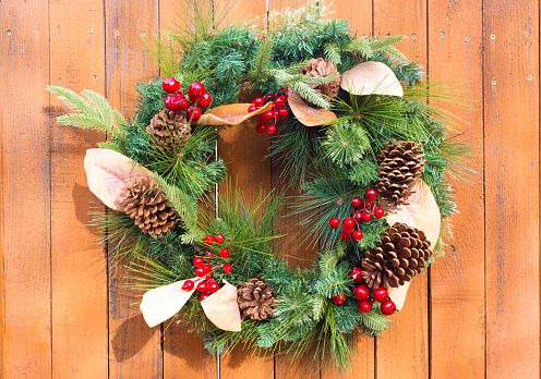 Green Christmas Wreath, Pinecones, Berries, Rustic Wood Door. Shot in Santa Fe, NM.