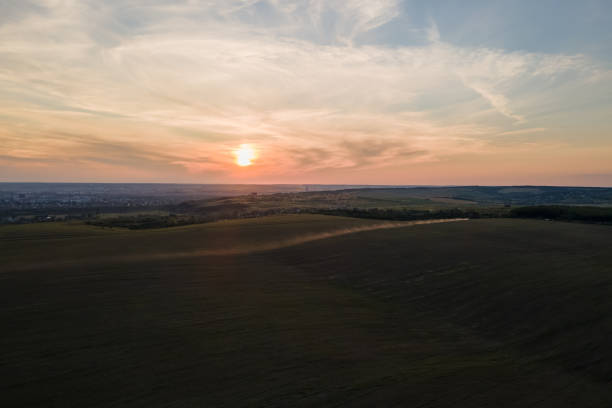 istock Bright colorful sunset sky with setting sun and vibrant clouds over dark landscape 1870890468